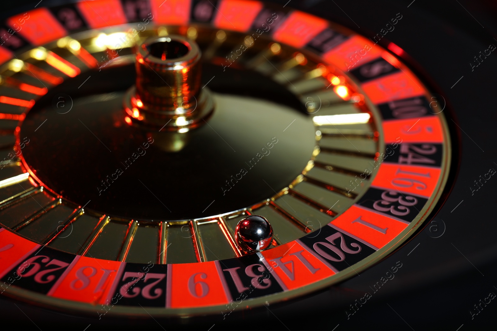 Photo of Roulette wheel with ball, closeup. Casino game