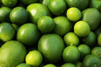 Photo of Fresh ripe green limes as background, closeup