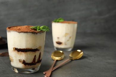 Photo of Tiramisu cake in glass on table, space for text