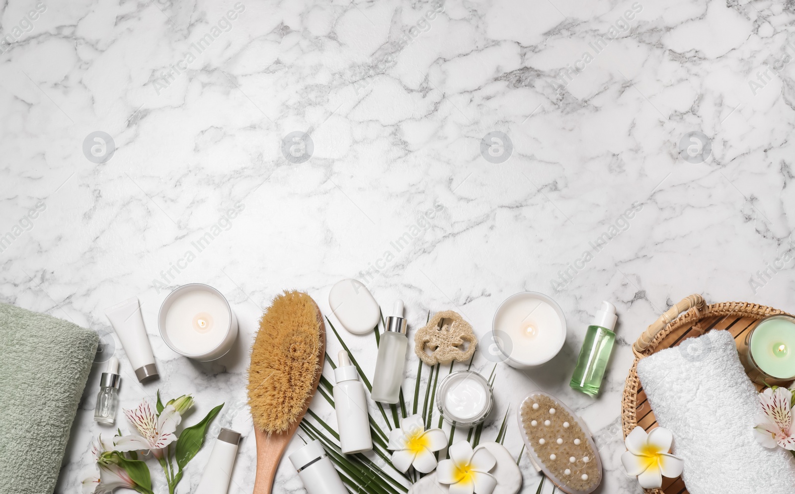 Photo of Flat lay composition with spa essentials on white marble background. Space for text