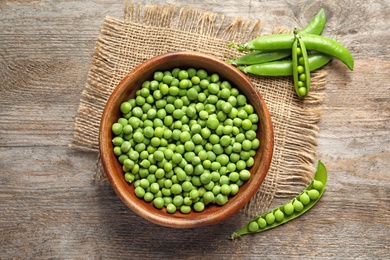 Photo of Flat lay composition with green peas on wooden background