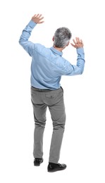 Mature businessman in stylish clothes avoiding something on white background, back view