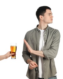 Man with car keys refusing alcohol while woman suggesting him beer on white background, closeup. Don't drink and drive concept