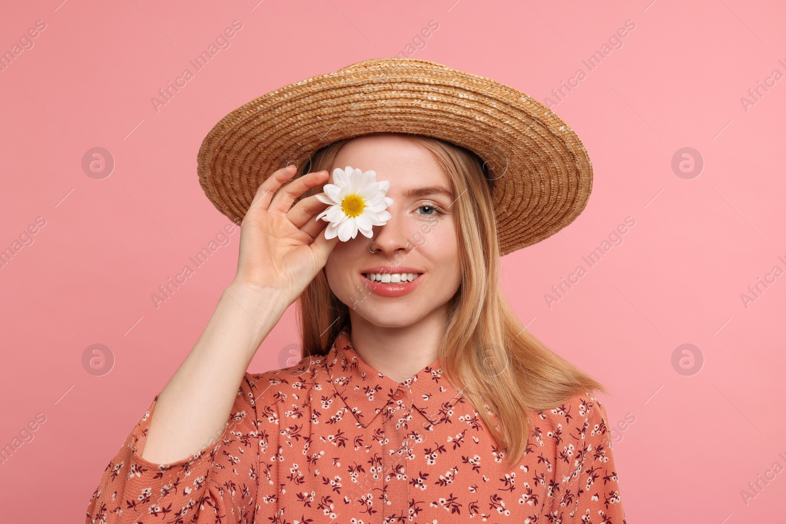 Photo of Beautiful woman with spring flower in hand on pink background