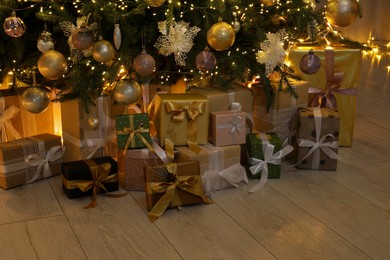 Many gift boxes under decorated Christmas tree at home