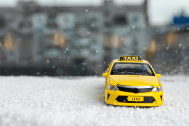 Photo of Yellow taxi car model on snow outdoors