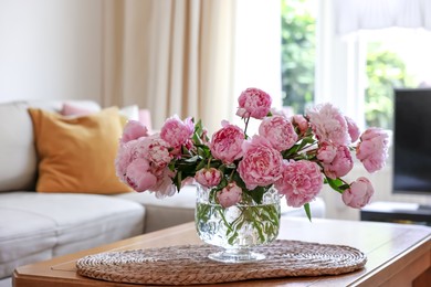 Beautiful pink peonies in vase on table at home, space for text. Interior design