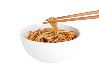 Photo of Chopsticks with tasty cooked noodles over bowl isolated on white
