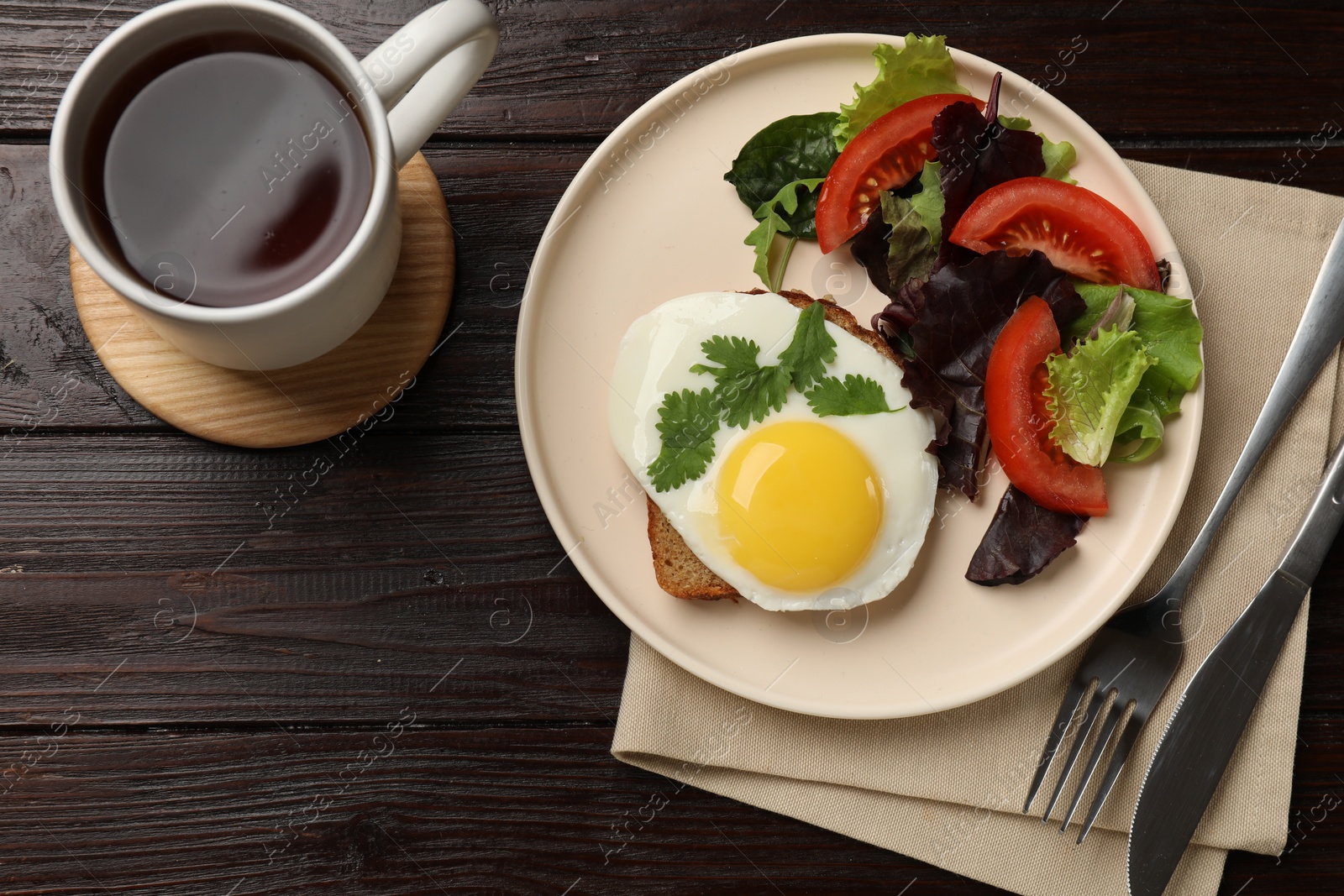 Photo of Delicious breakfast with fried egg and salad served on wooden table, flat lay