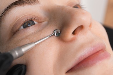 Cosmetologist using scrubber, closeup. Client having cleansing procedure