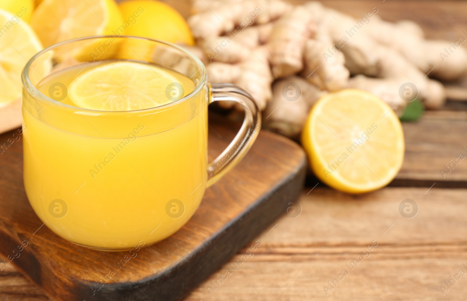 Photo of Immunity boosting drink and ingredients on wooden table, closeup. Space for text