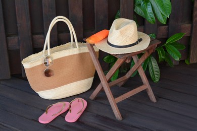 Photo of Different stylish beach accessories near wooden fence