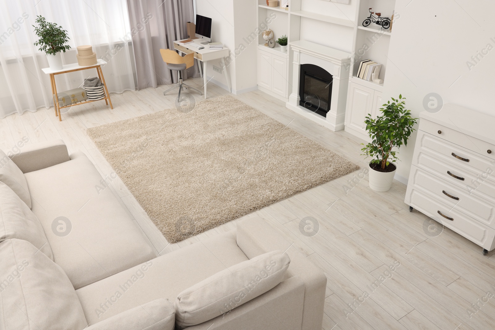 Photo of Stylish room with beautiful rug near fireplace. Interior design