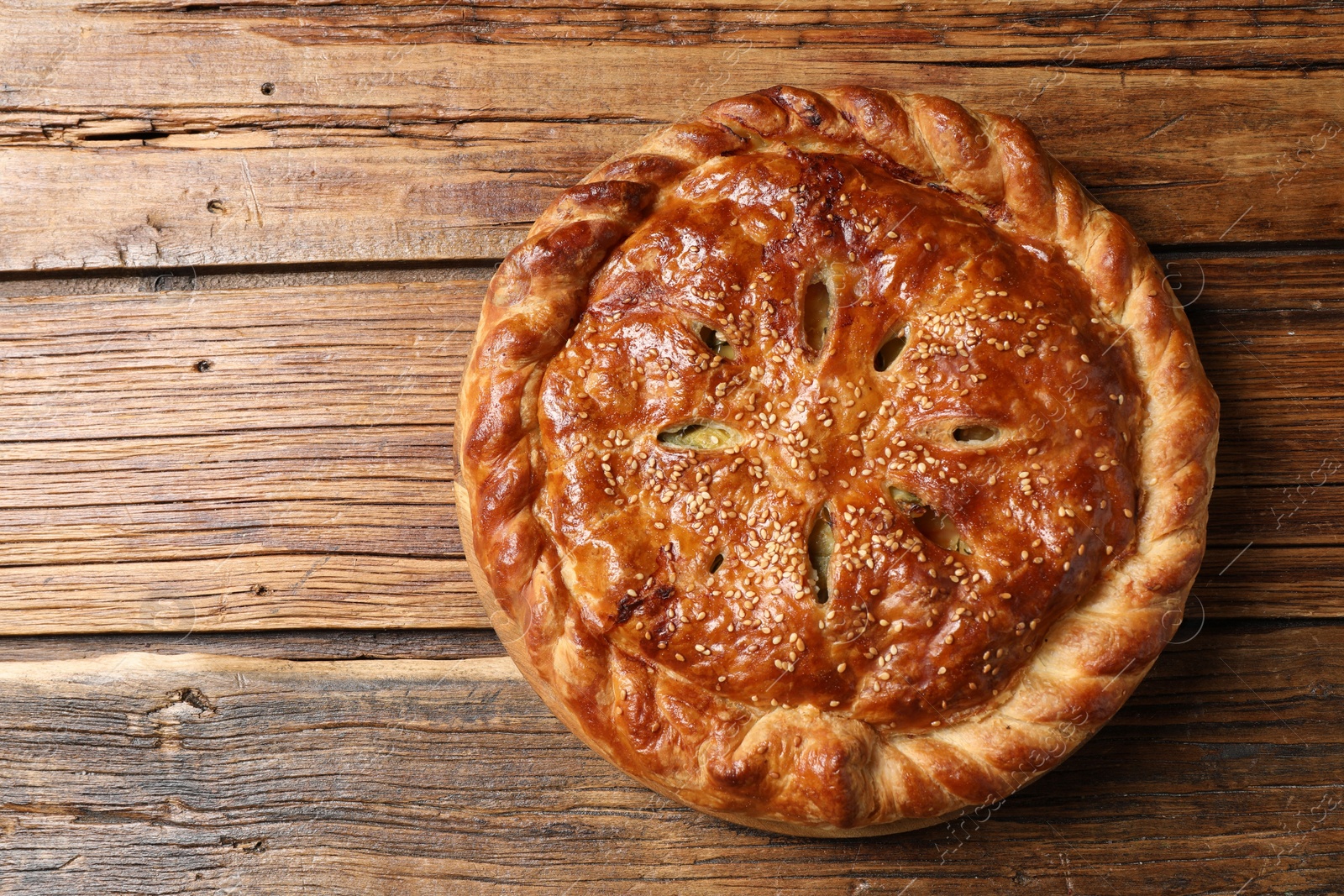 Photo of Tasty homemade pie with filling on wooden table, top view. Space for text