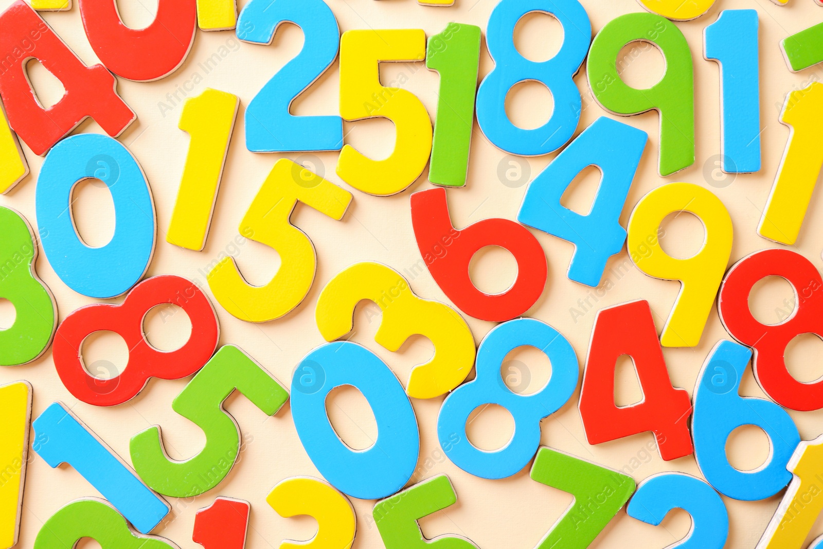 Photo of Colorful numbers on beige background, flat lay