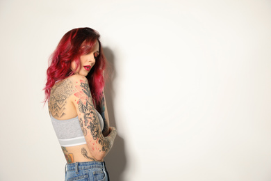 Beautiful woman with tattoos on body against white background. Space for text