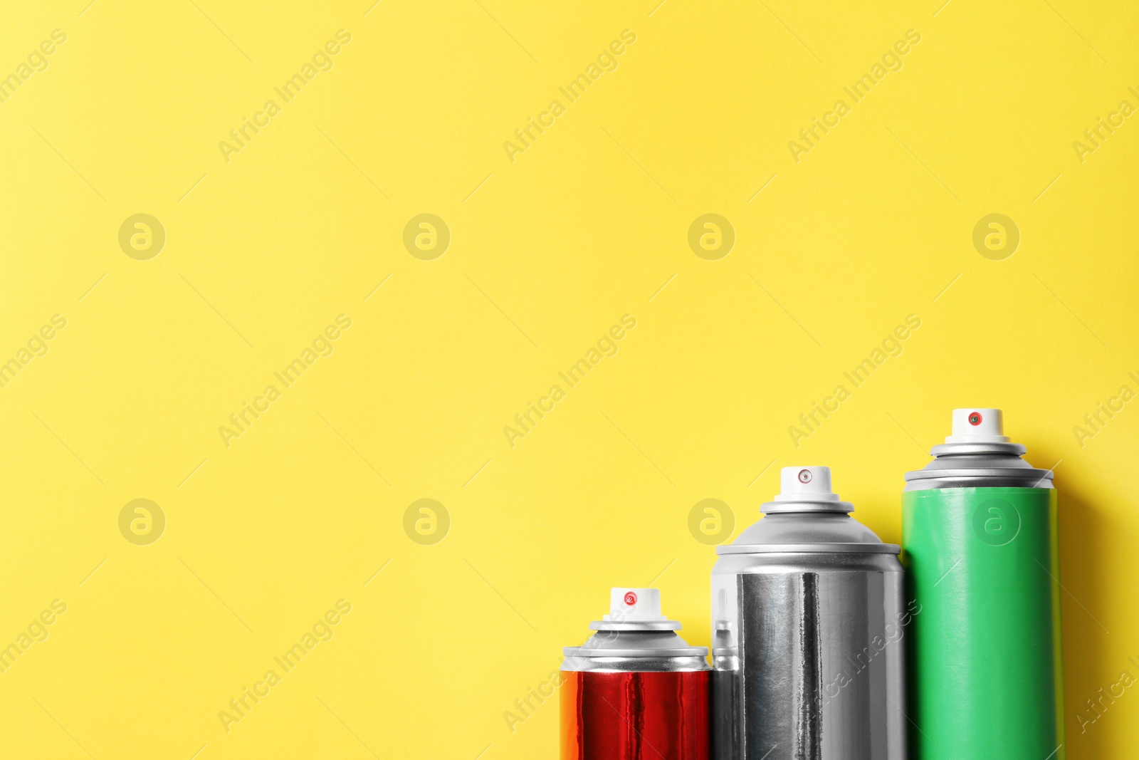 Photo of Cans of spray paint on color background, flat lay. Space for text