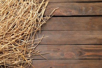 Photo of Dried straw on wooden table, top view. Space for text