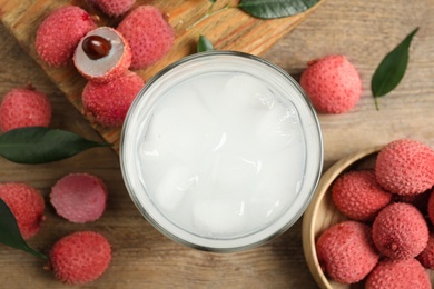 Photo of Fresh lychee juice and fruits on wooden table, flat lay