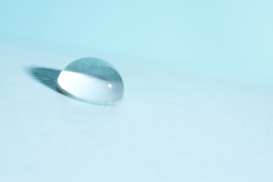 Photo of Macro photo of water drop on light blue background. Space for text