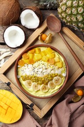 Photo of Tasty smoothie bowl with fresh fruits served on wooden table, flat lay