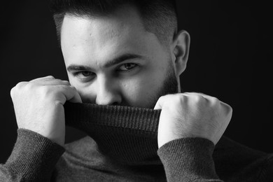 Photo of Portrait of handsome bearded man on dark background. Black and white effect