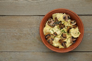 Photo of Delicious ravioli with mushrooms on wooden table, top view. Space for text