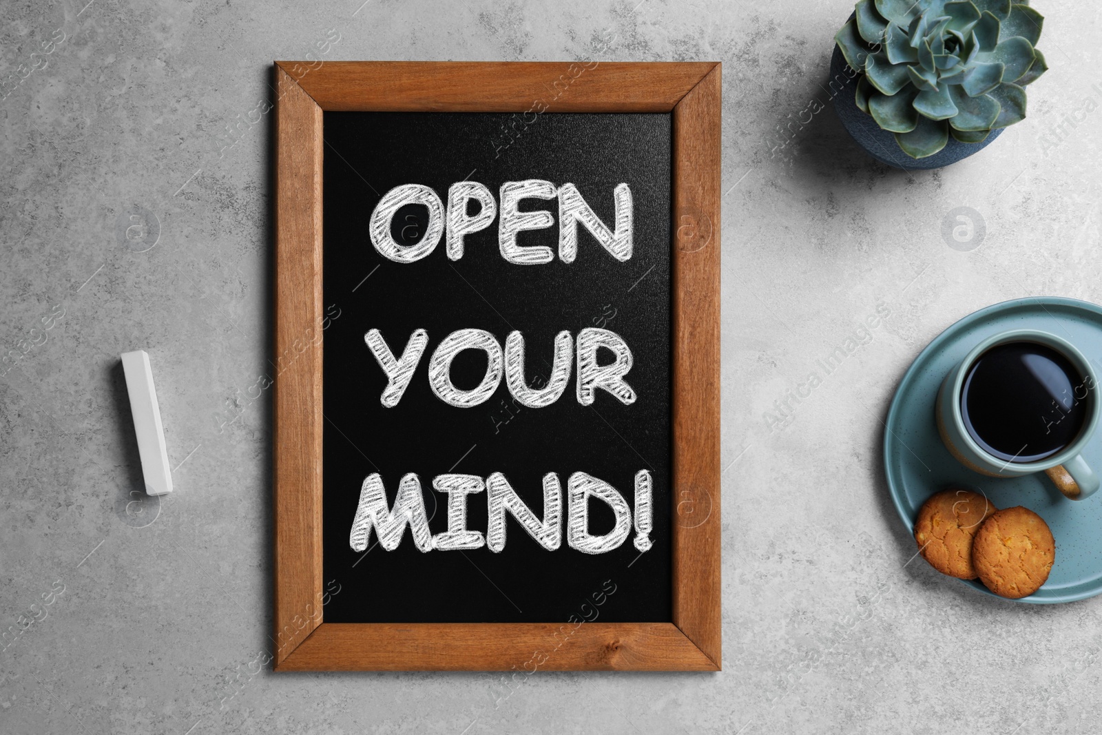 Image of Small chalkboard with motivational quote Open your mind, coffee and cookies on light grey table, flat lay