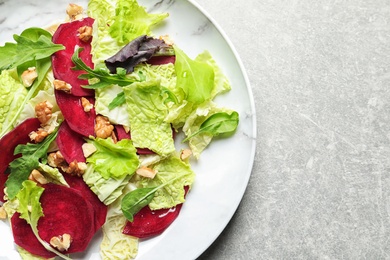 Plate with delicious beet salad on grey background, top view