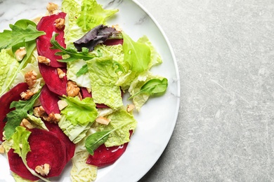 Photo of Plate with delicious beet salad on grey background, top view