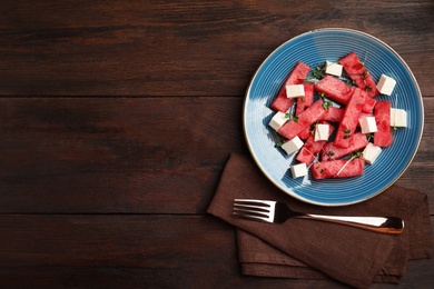 Photo of Delicious salad with watermelon and feta cheese on wooden table, flat lay. Space for text