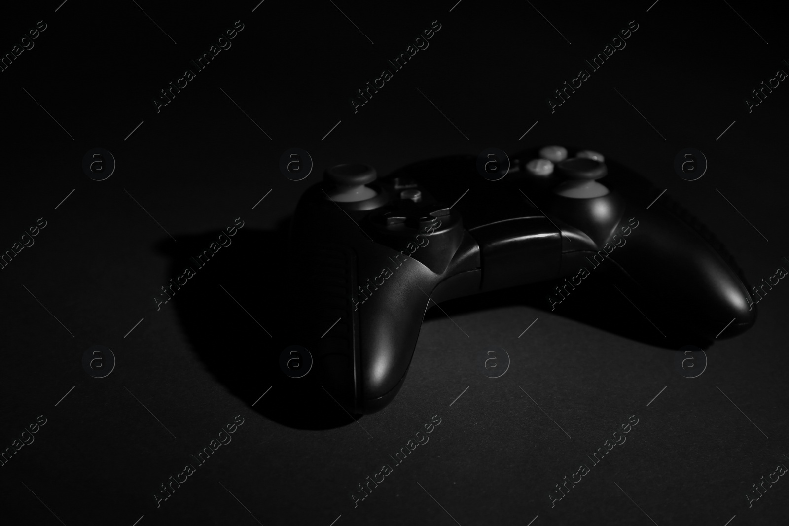 Photo of Video game controller on black background, space for text