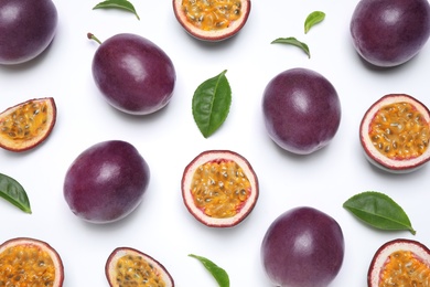 Fresh ripe passion fruits (maracuyas) with leaves on white background, flat lay