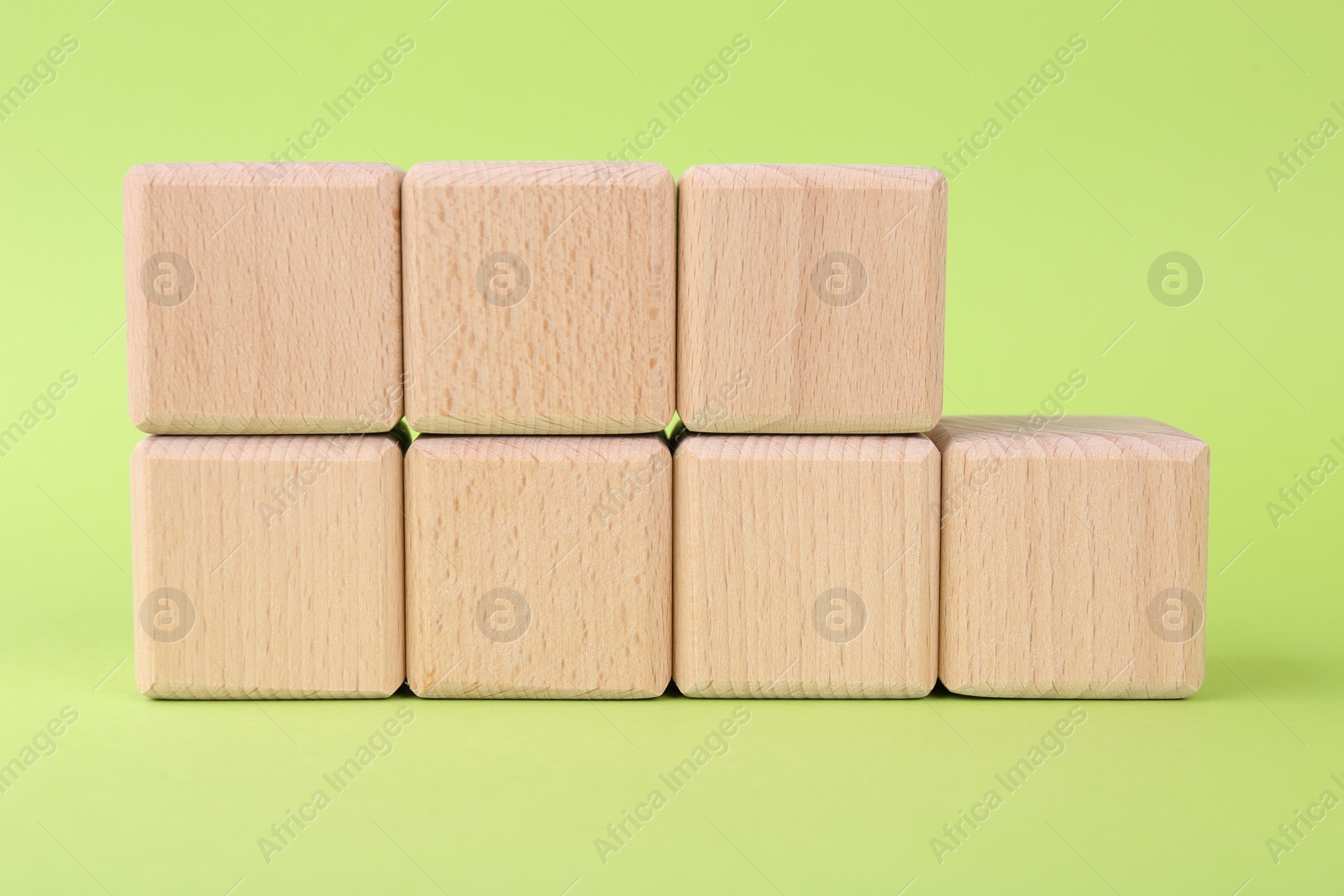 Photo of International Organization for Standardization. Wooden cubes with abbreviation ISO and number 9001 on light green background, closeup