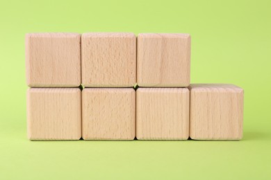 Photo of International Organization for Standardization. Wooden cubes with abbreviation ISO and number 9001 on light green background, closeup