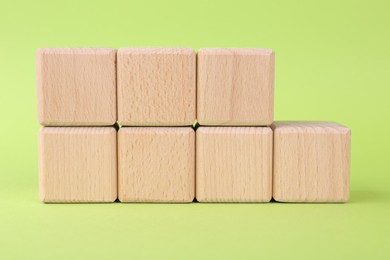 International Organization for Standardization. Wooden cubes with abbreviation ISO and number 9001 on light green background, closeup