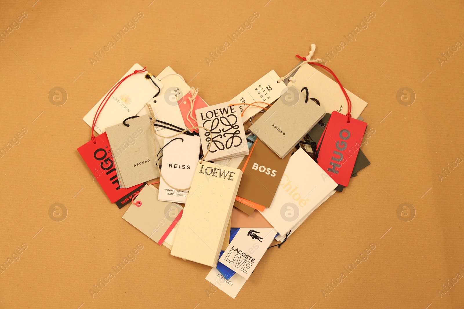 Photo of Leiden, Netherlands - December 6, 2023: Heart of different clothing tags on kraft paper sheet, top view