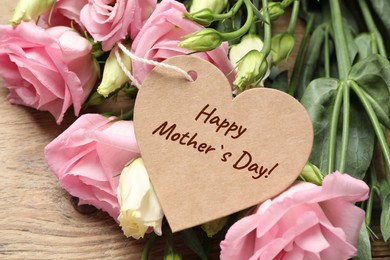 Image of Happy Mother's Day. Heart shaped greeting label and beautiful flowers on wooden table