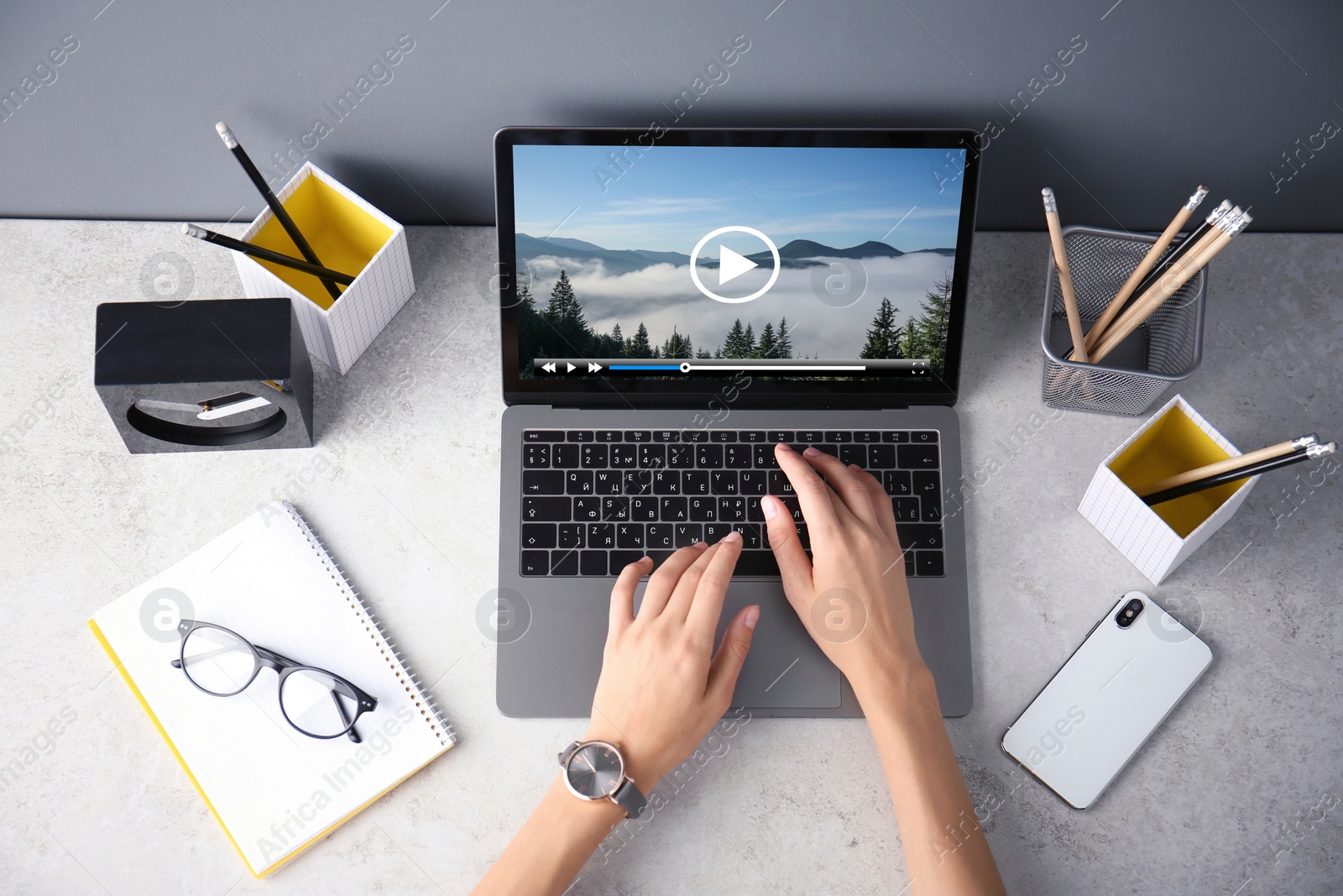 Image of Woman watching video on laptop at office desk, closeup. Top view