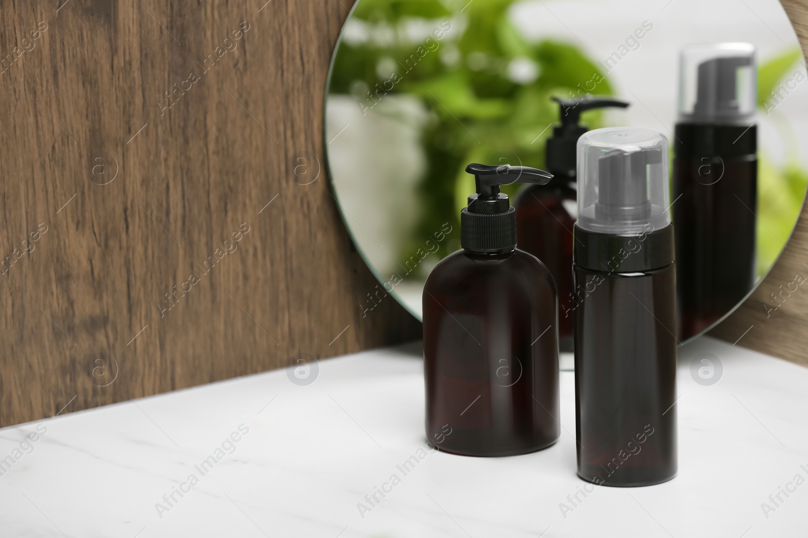 Photo of Different face cleansing products near mirror on white table. Space for text