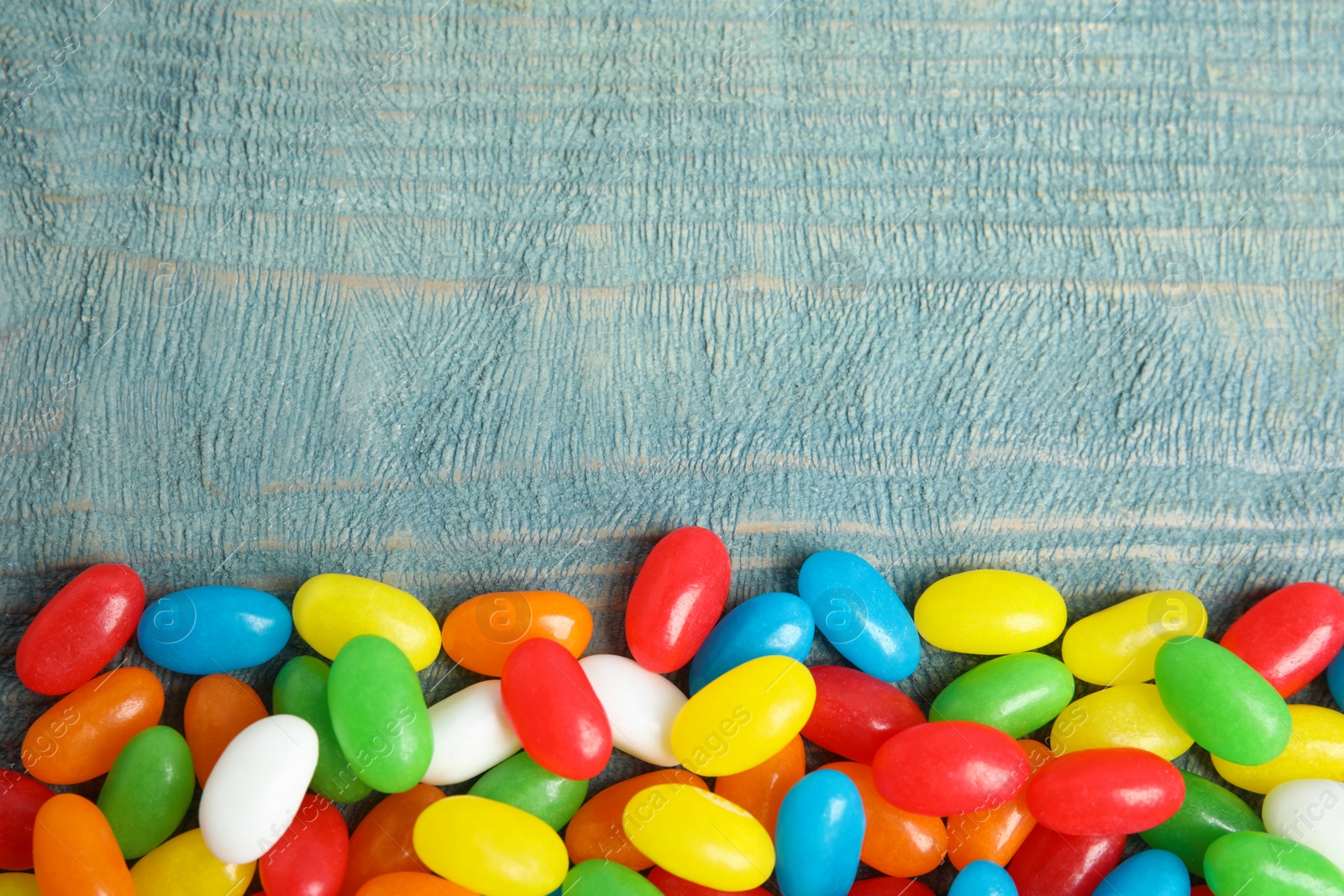 Photo of Flat lay composition with jelly beans on color background. Space for text