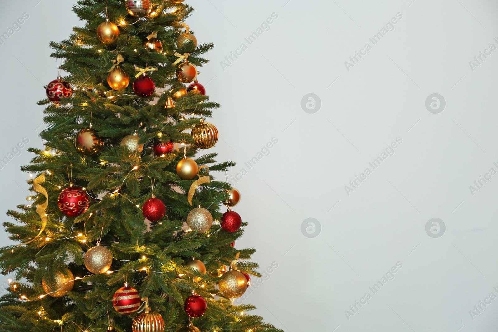 Photo of Beautiful Christmas tree with fairy lights and festive decor on white background