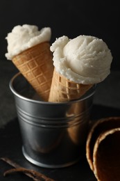 Photo of Ice cream scoops in wafer cones on table, closeup
