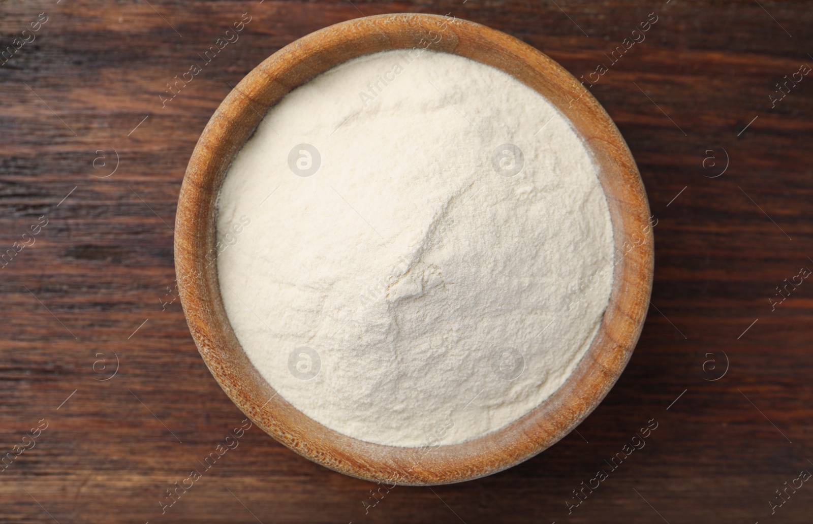 Photo of Bowl of agar-agar powder on wooden table, top view