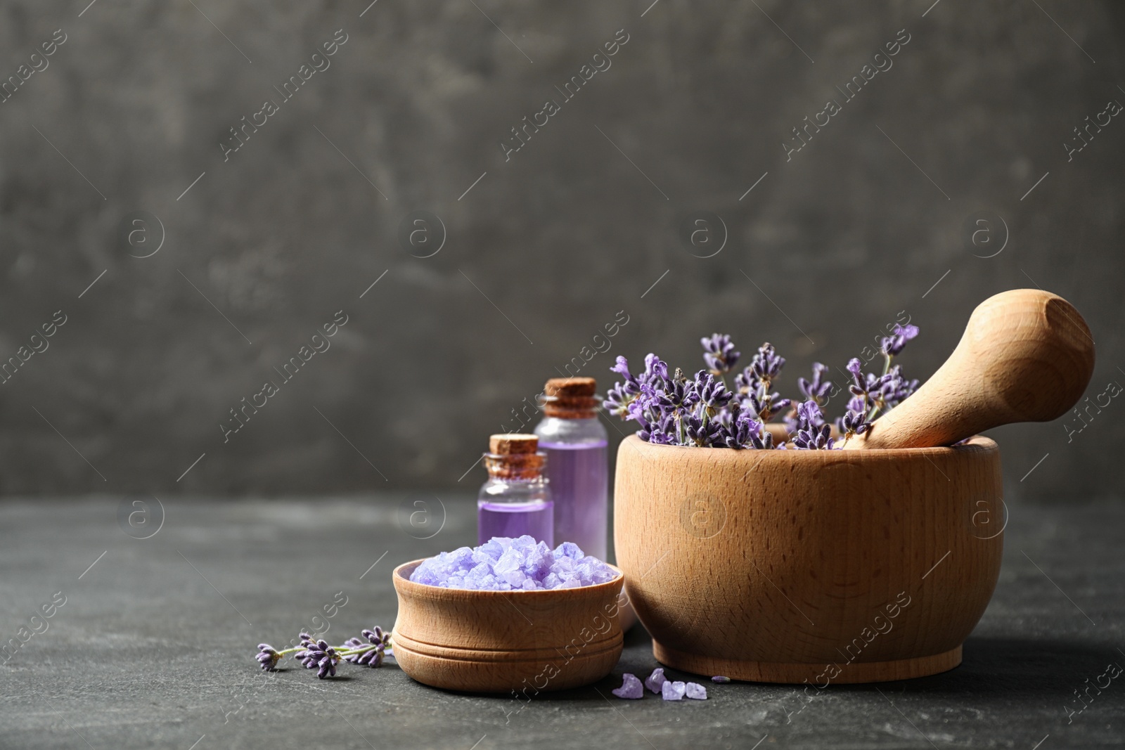 Photo of Cosmetic products and lavender flowers on dark grey background. Space for text