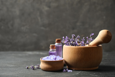 Cosmetic products and lavender flowers on dark grey background. Space for text