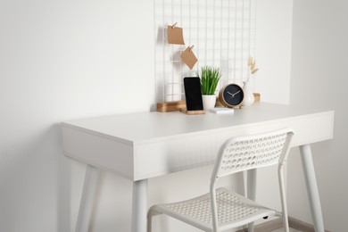 Comfortable workplace with white desk near wall at home