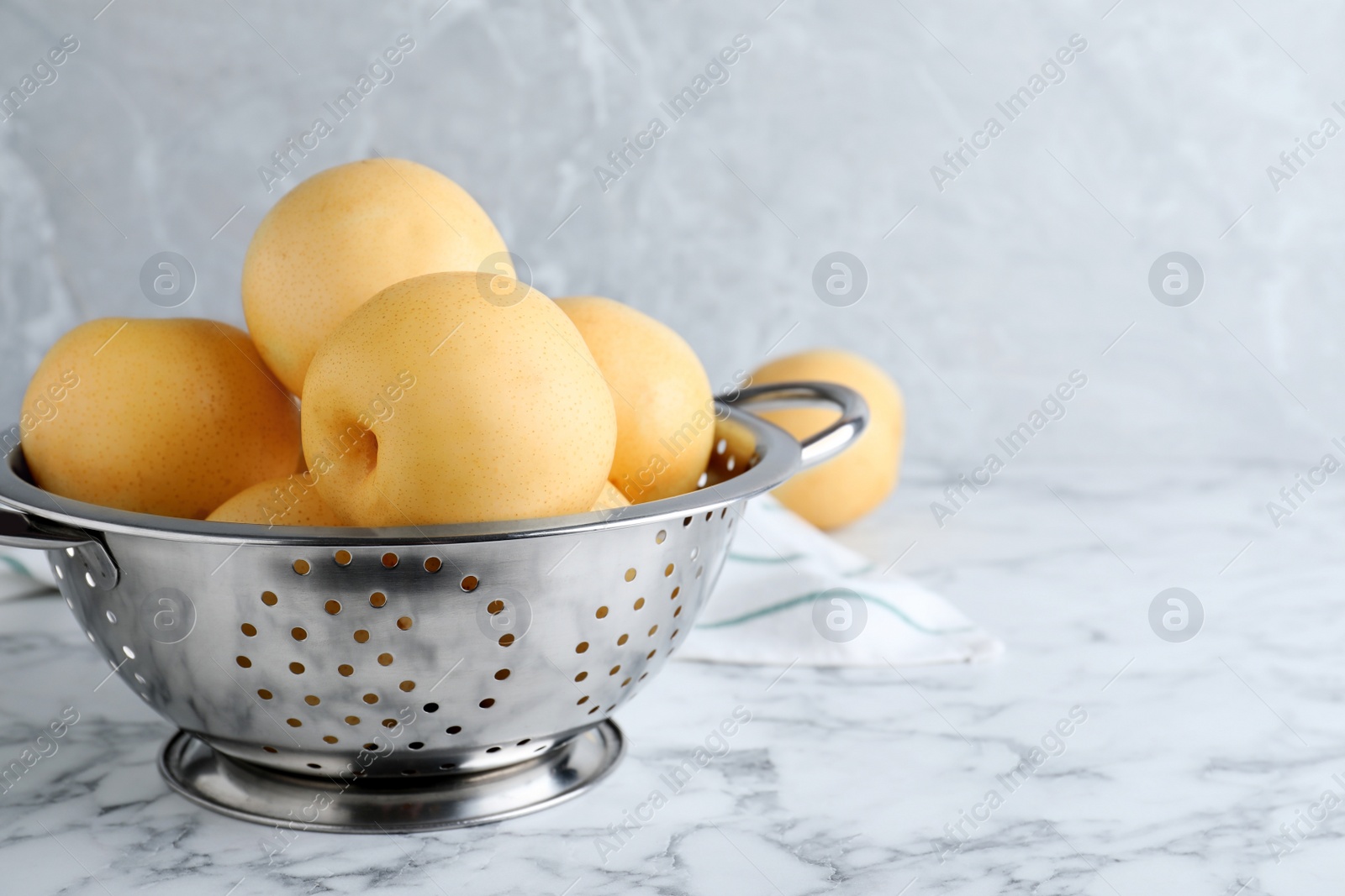 Photo of Ripe apple pears on white marble table. Space for text