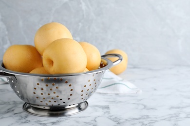 Photo of Ripe apple pears on white marble table. Space for text