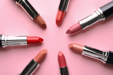 Photo of Flat lay composition with lipsticks on color background